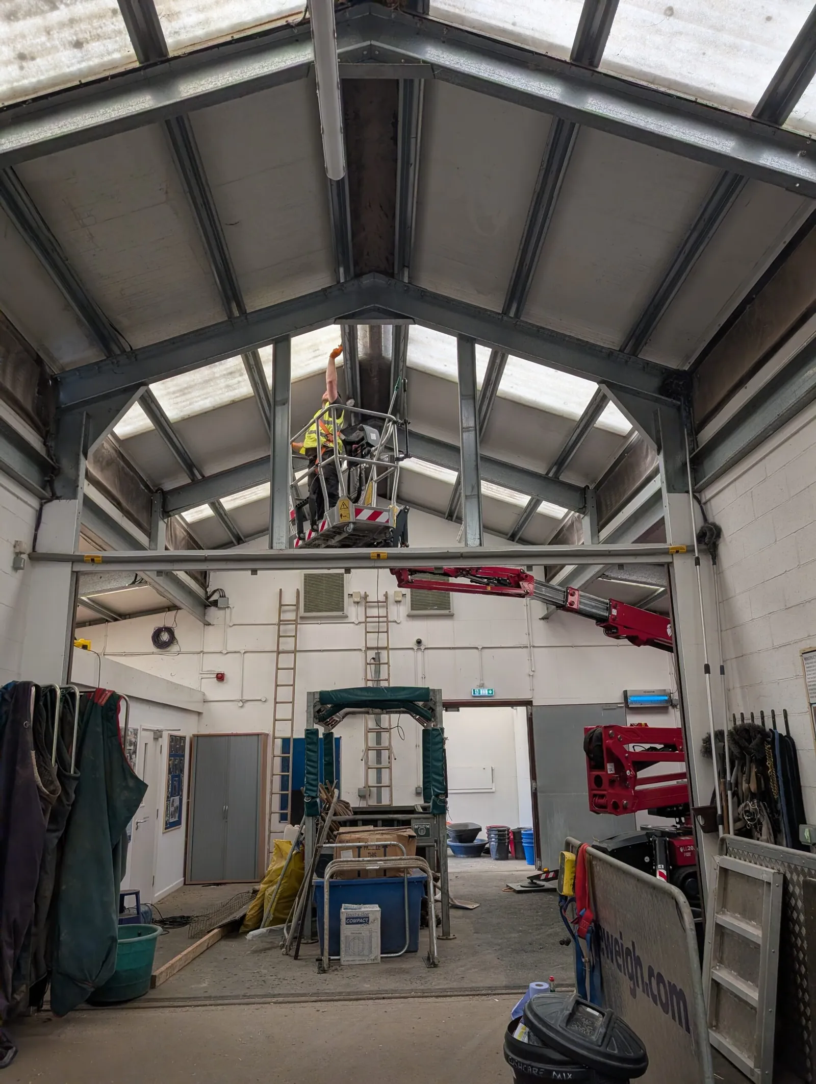 A LADS spider lift raised to the apex of a barn roof, giving internal access to the steel trusses and rooflights without a scaffold